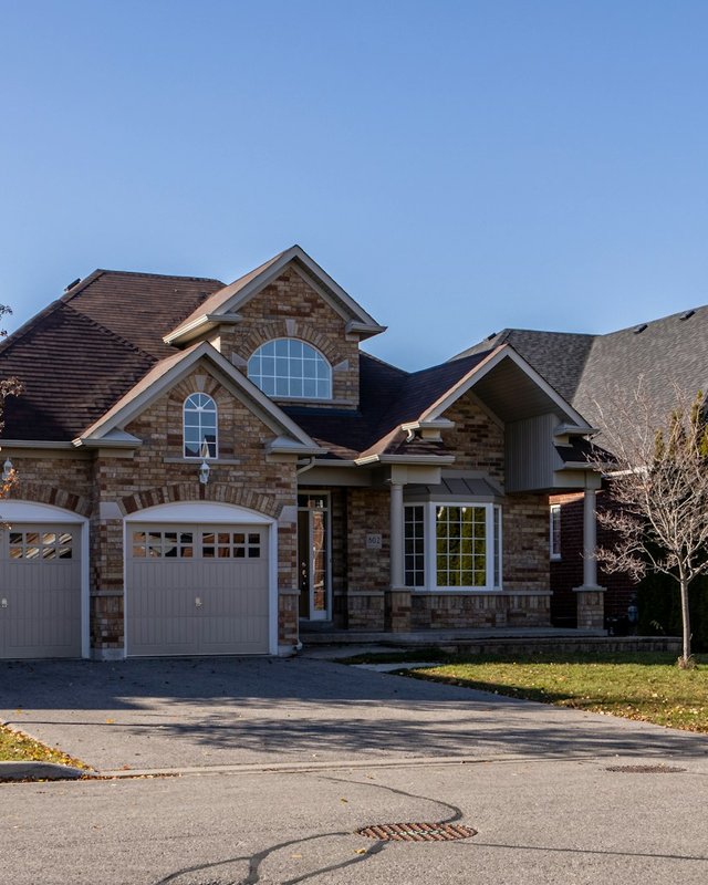 Brick suburban home with a bay window on a quiet neighborhood street